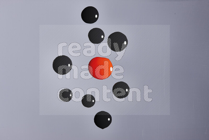 Close-ups of abstract red and black paint droplets on the surface