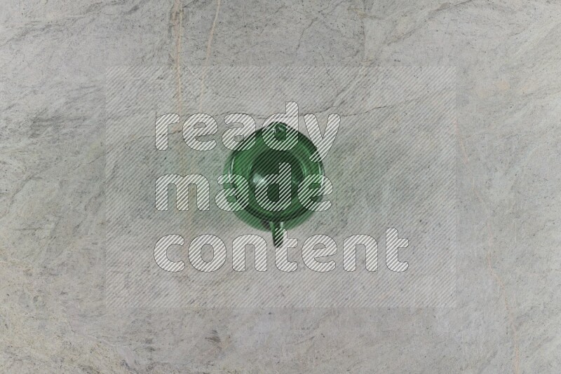 A colored glass jug on grey marble background