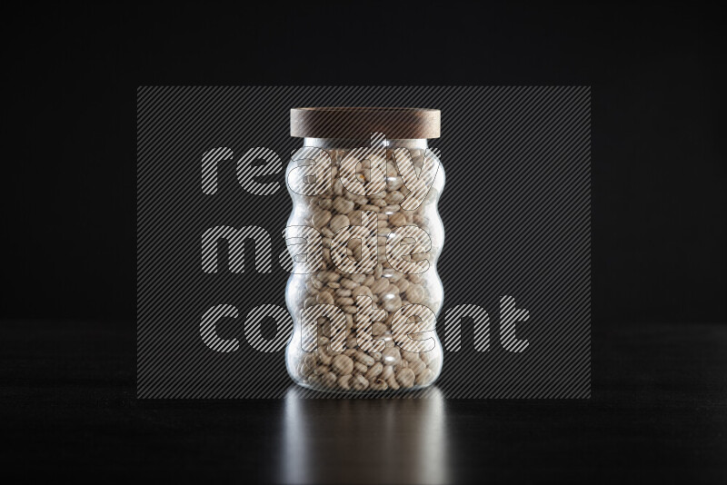 Lupin Beans in a glass jar on black background