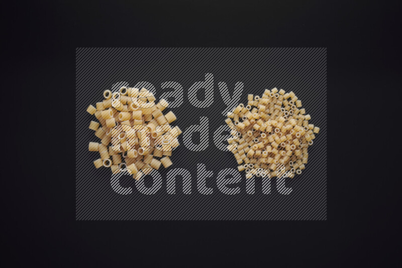 Different pasta types in bunches on black background