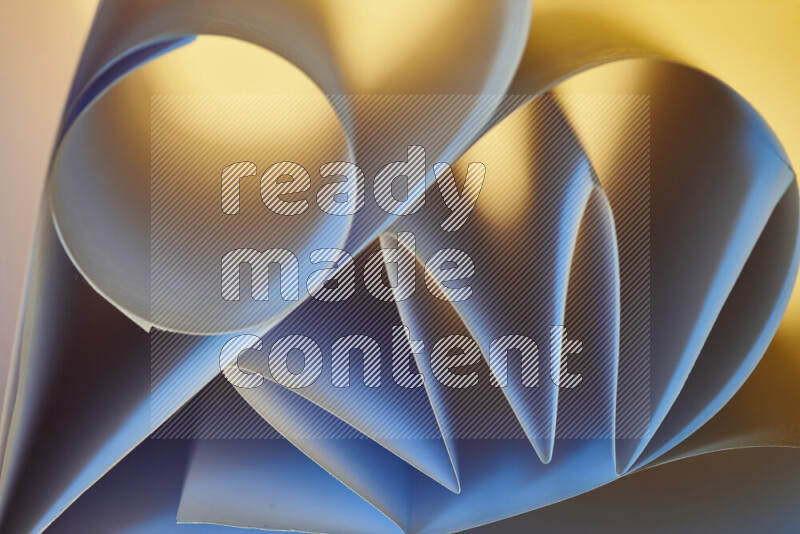An artistic display of paper folds creating a harmonious blend of geometric shapes, highlighted by soft lighting in blue and warm tones