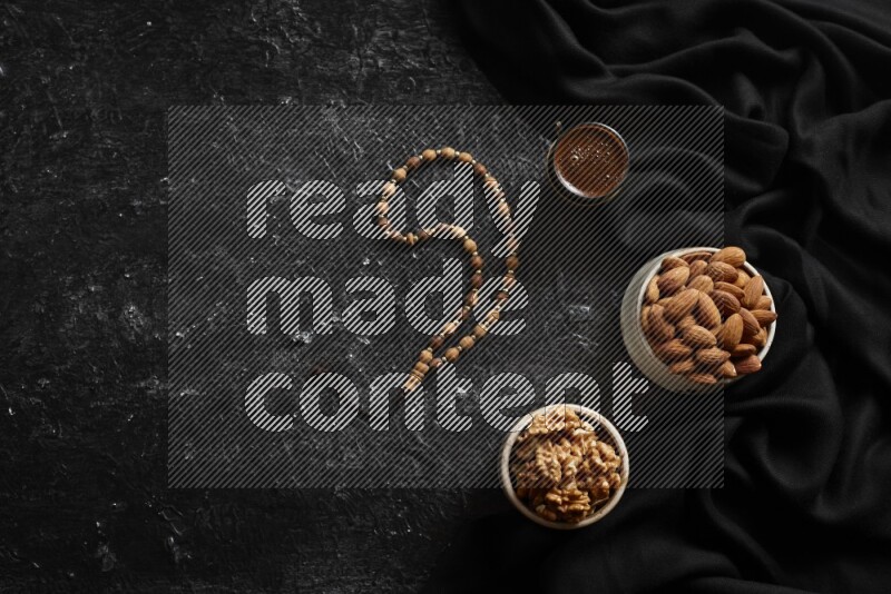 Nuts in pottery bowls with coffee in a dark setup