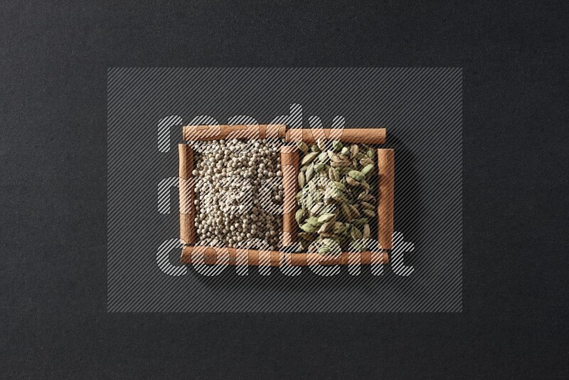 2 squares of cinnamon sticks full of white peppers and cardamom on black flooring