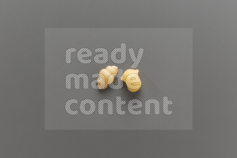 Snails pasta with other types of pasta on grey background