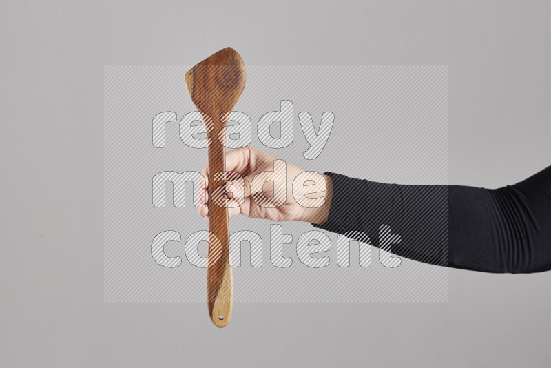 A woman in black abaya holding different wooden essentials in different positions