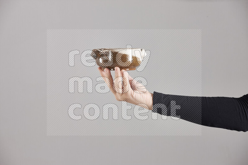 A woman in black abaya holding different pottery essentials in different positions