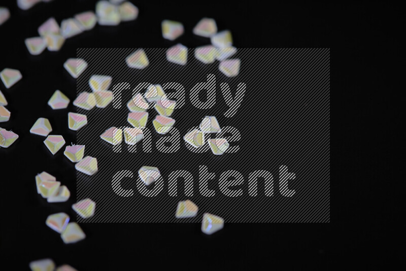 Colorful plastic shards for decoration scattered on a black background