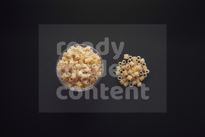 Big rings pasta in a glass bowl on black background