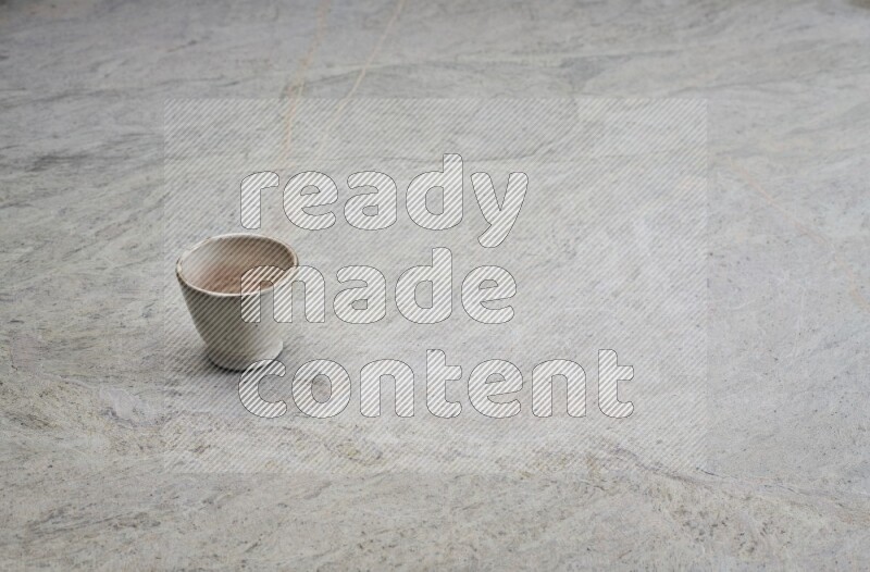 A multicolored pottery Cup on grey marble background