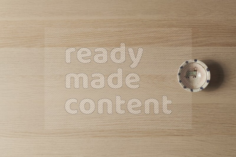 A decorative pottery bowl on light wooden background