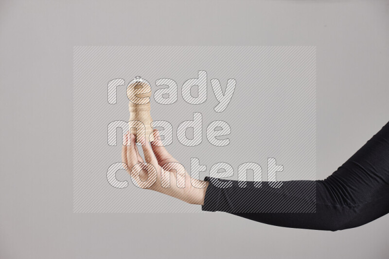 A woman in black abaya holding different wooden essentials in different positions