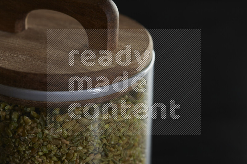 Freekeh in a glass jar on black background