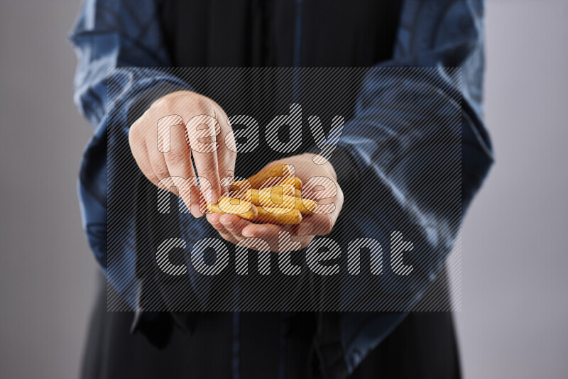 Woman in abaya holding different kinds of snacks in different positions