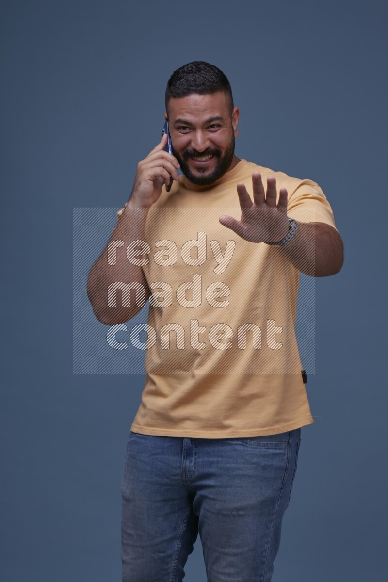 A man Calling on Blue Background wearing Orange T-shirt