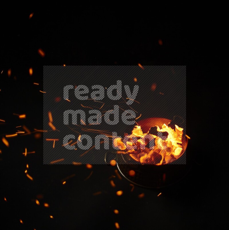 Coal cubes on fire in metal pan