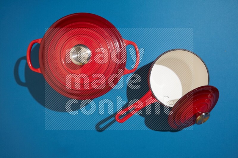 red and white pan and pot on blue background