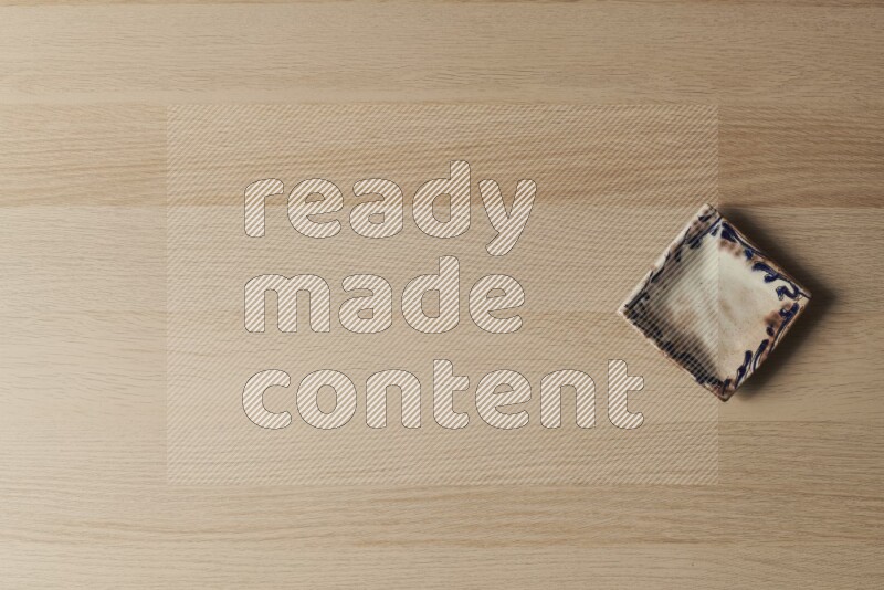 A decorative pottery plate on light wooden background