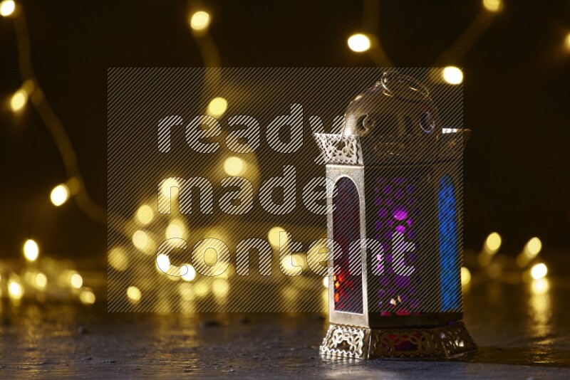 A traditional ramadan lantern surrounded by glowing fairy lights in a dark setup