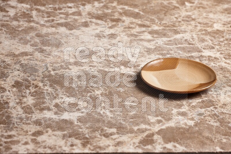 A multicolored pottery plate on beige marble background