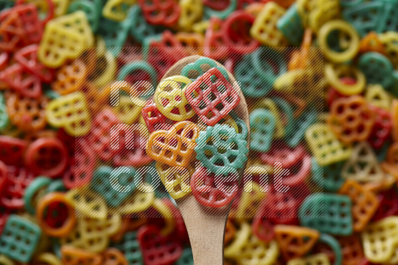 A wooden spoon full of snacks on snacks background