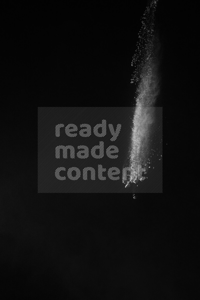 A side view of white powder explosion on black background