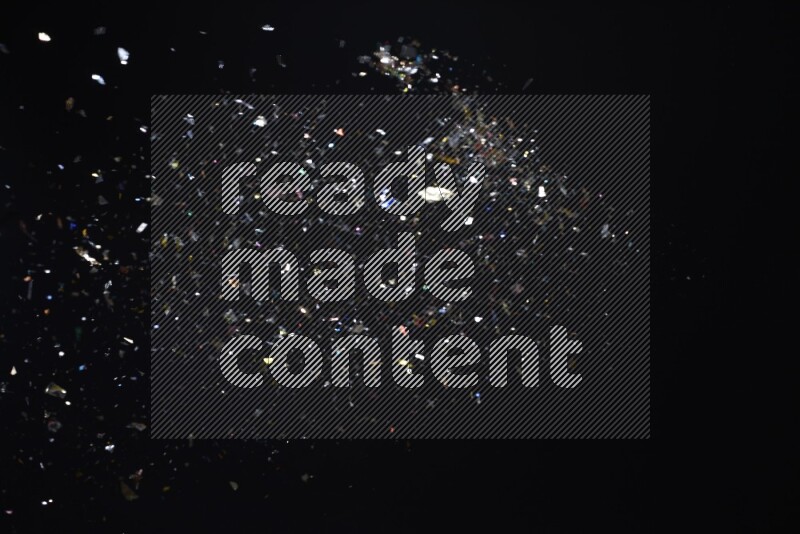 Falling multicolored confetti on black background