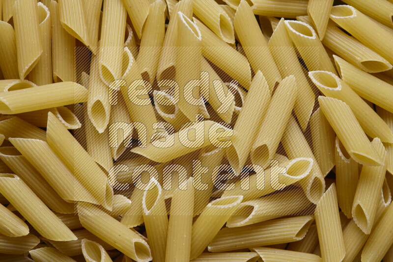 Penne pasta on grey background