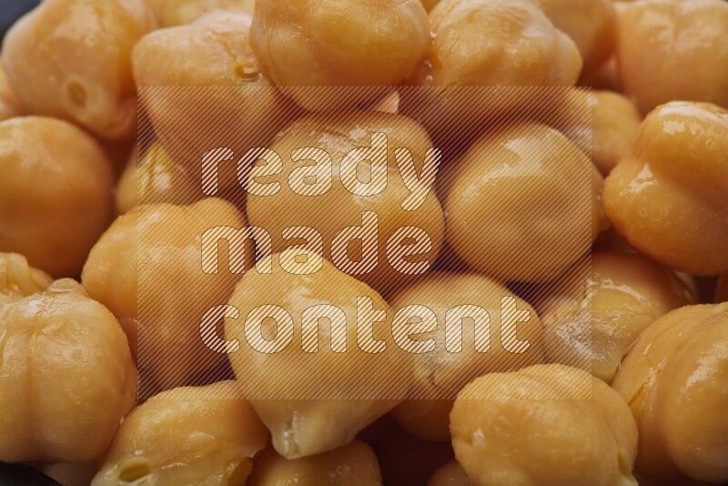 Close up shot of boiled chickpeas in a container on white background