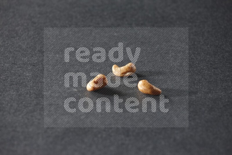 3 cashews on a black background in different angles