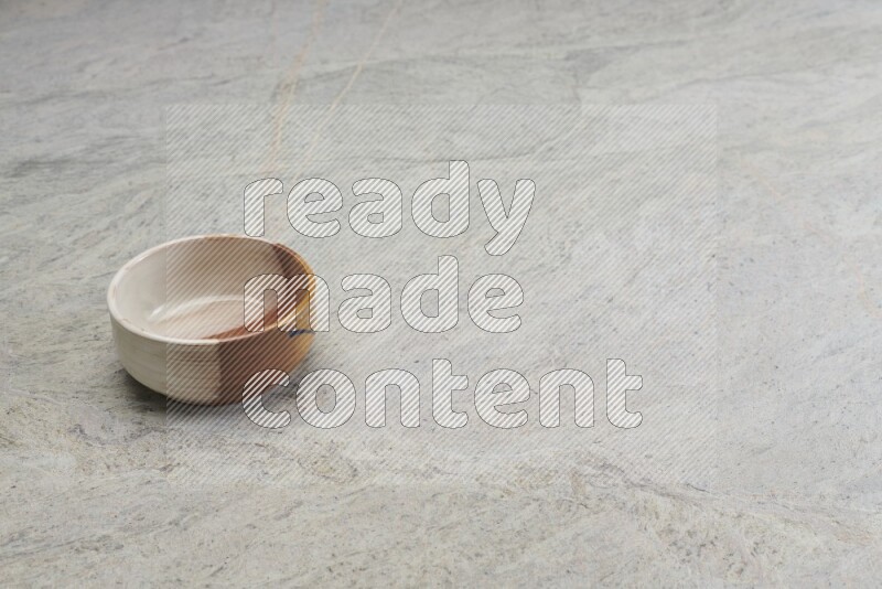 A multicolored pottery bowl on grey marble background