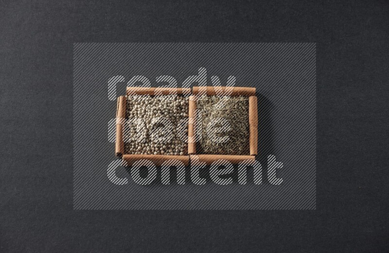 2 squares of cinnamon sticks full of white peppers and cumin on black flooring