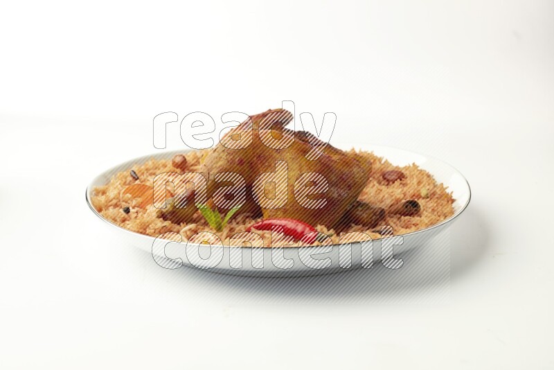 red basmati Rice with  kabsa chicken pieces on a white plate with a silver rim direct  on white background