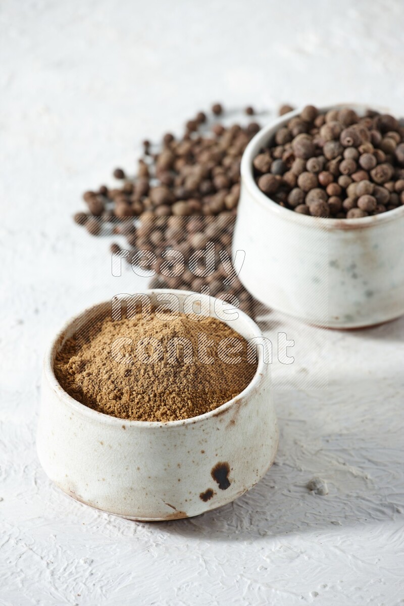 2 beige bowls, one full of powder and the other full of whole balls with balls and powder spreaded on a textured white flooring