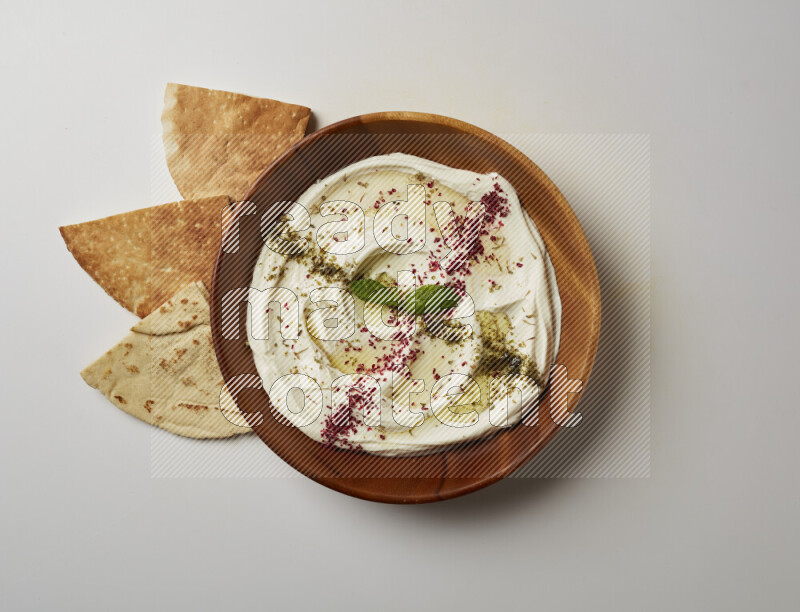 Lebnah garnished with  zattar , sumak & mint in a wooden plate on a white background