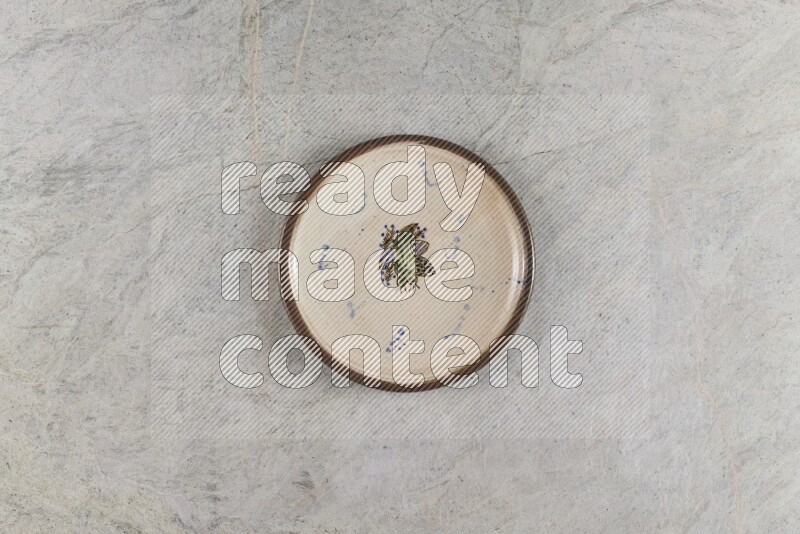 A decorative pottery plate on grey marble background