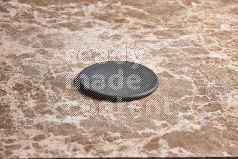 A pottery coaster on beige marble background