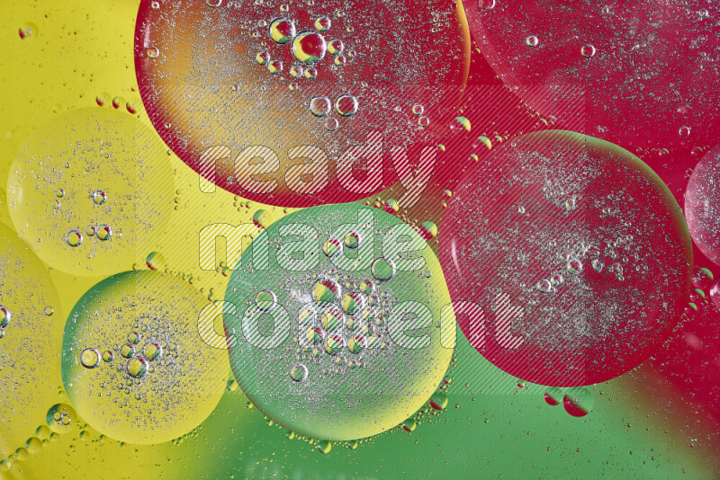 Close-ups of abstract oil bubbles on water surface in shades of yellow, green and red
