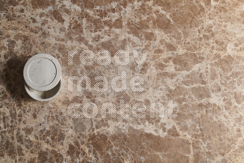 A pottery cup on beige marble background