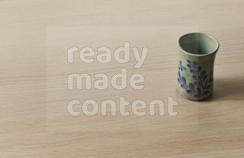 A pottery cup on light wooden background