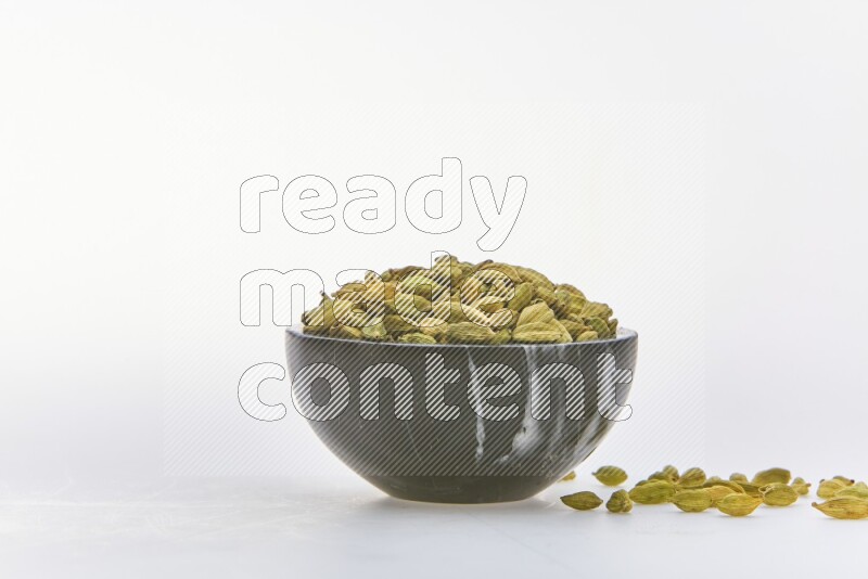 Cardamon in a container on white background