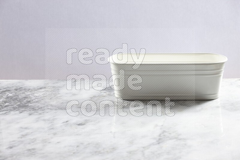 An empty white plant pot on grey marble background