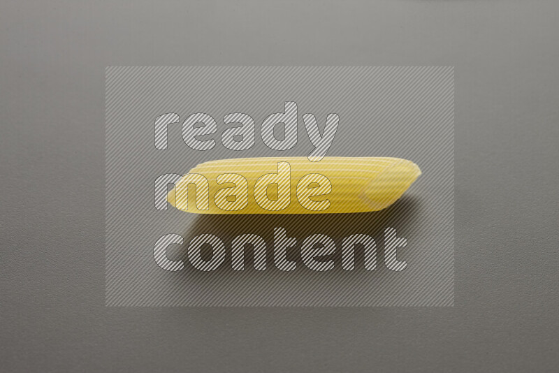 Penne pasta on grey background