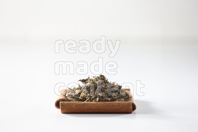 A single square of cinnamon sticks full of dried basil on white flooring