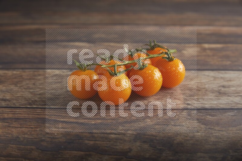 Orange cherry tomato vein on a textured wooden background 45 degree