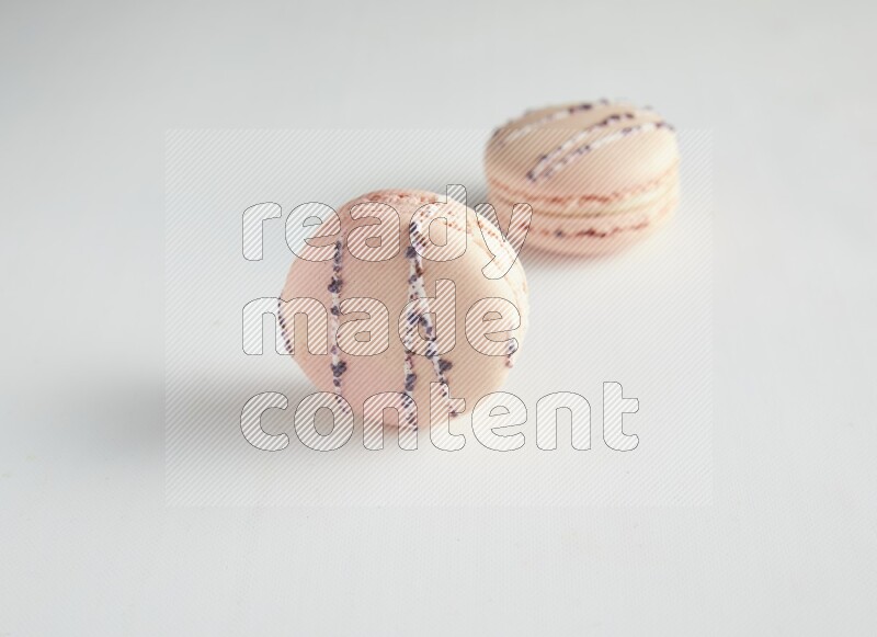 45º Shot of two pink orange blossom macarons on white background