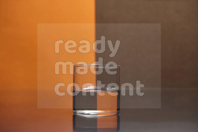 The image features a clear glassware filled with water, set against orange and brown background