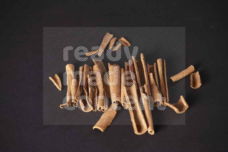 Cracked cinnamon sticks on a black background