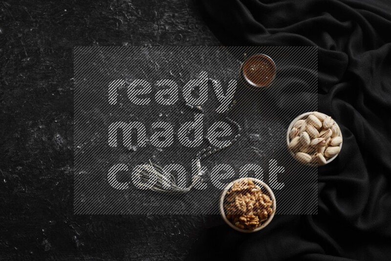 Nuts in pottery bowls with coffee in a dark setup