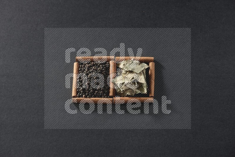 2 squares of cinnamon sticks full of black peppers and bay laurel leaves on black flooring