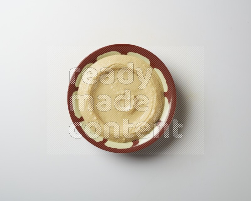 Plain hummus in a traditional plate on a white background